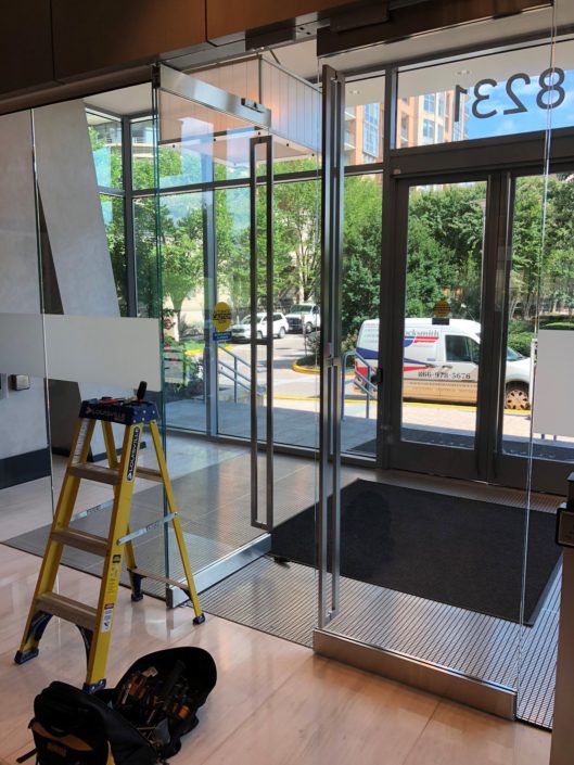 A ladder and some steps in front of a glass door.