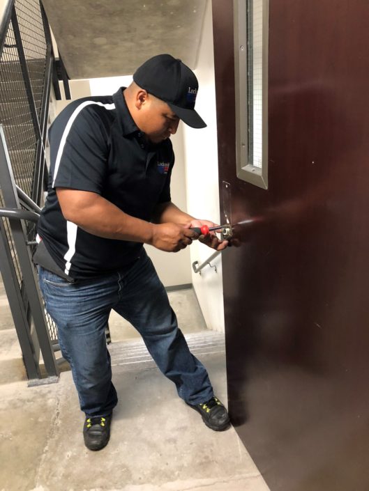 A man in black shirt and hat opening door.