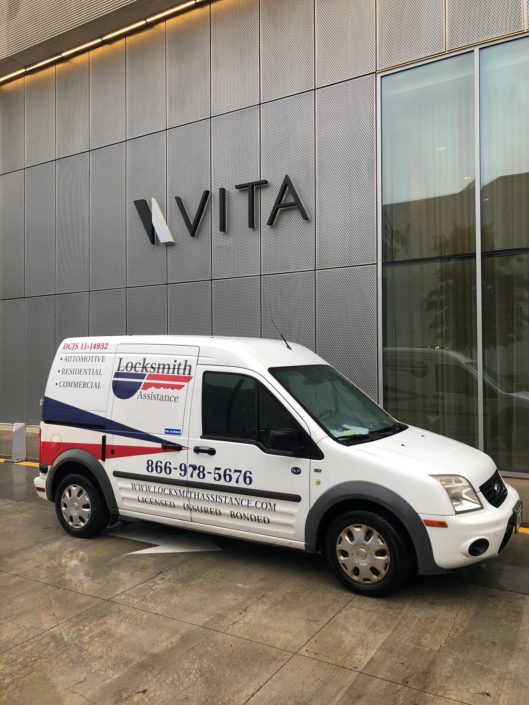 A white van parked in front of a building.