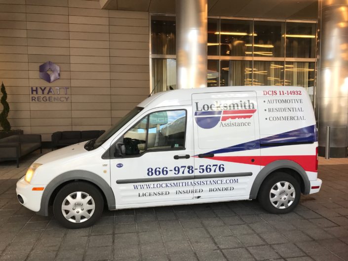 A white van parked in front of a building.